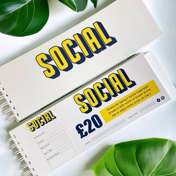 Picture of a gift voucher book for small businesses, cheque book style on a white wood backround with a feminine flat lay.