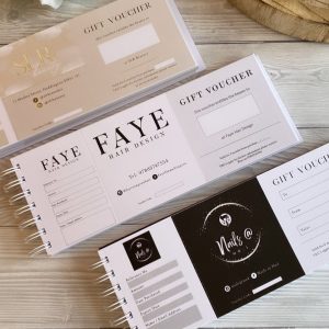 Picture of a gift voucher book for small businesses, cheque book style on a white wood backround with a feminine flat lay.